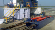 Linear winch and hydraulic power unit setup during pulling operation. The winch is anchored with a hold back arrangement in excess of 3000 kN. At the rear end of the winch, the specialised shackles with load cells can be seen